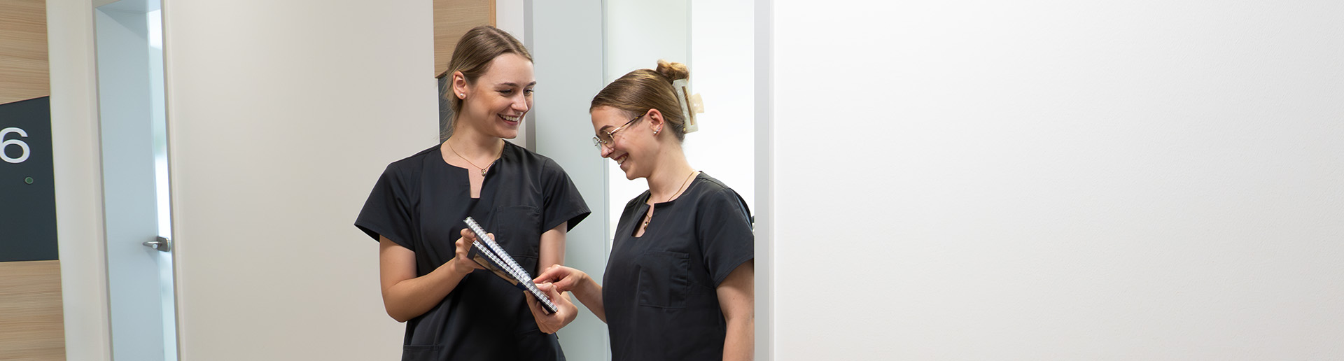 Zwei Kolleginnen besprechen sich im Praxisflur.