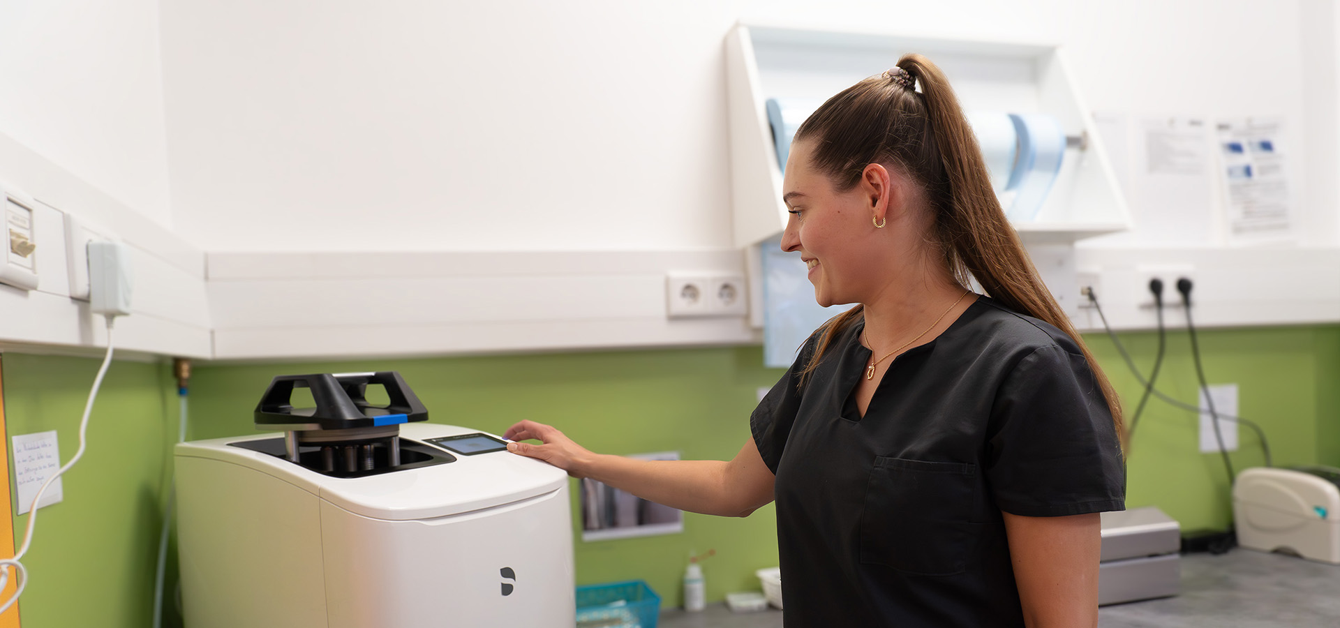 Eine zahnmedizinische Fachangestellte arbeitet im Sterilisationsraum.